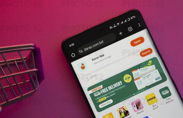 Dhaka, Bangladesh- 03 Oct 2025: A smartphone displaying the Daraz website with a shopping cart is shown on a vibrant background