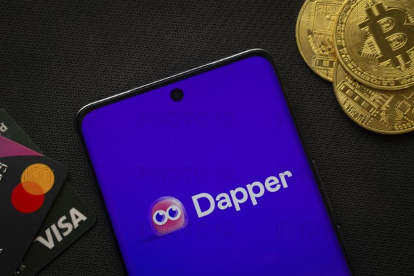 Dhaka, Bangladesh- 03 Oct 2025: Smartphone displaying Dapper logo surrounded by Bitcoin coins and payment cards