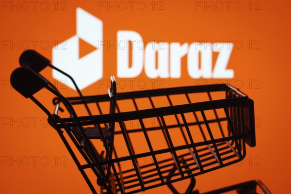 Dhaka, Bangladesh- 03 Oct 2025: Silhouette of a shopping cart in front of the Daraz logo, symbolizing ecommerce and online shopping
