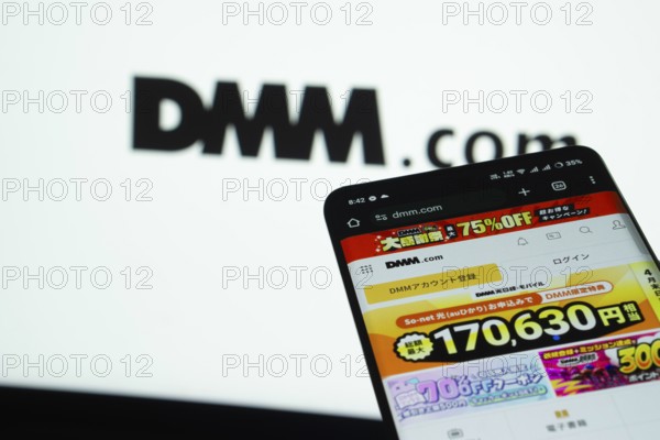 Dhaka, Bangladesh- 03 Oct 2025: Smartphone displaying Dmm.com web interface against Dmm.com logo background