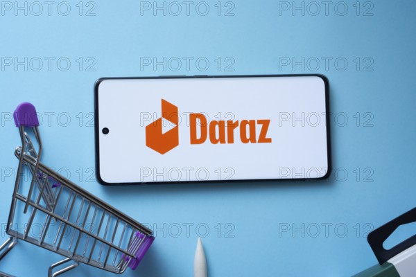Dhaka, Bangladesh- 03 Oct 2025: Smartphone displaying Daraz logo with shopping cart on a blue background