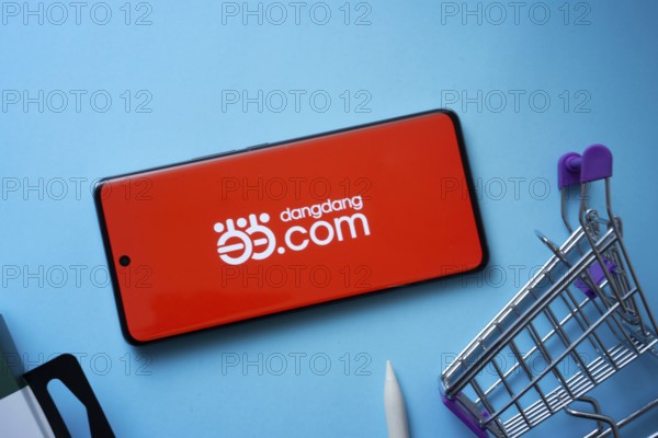 Dhaka, Bangladesh- 03 July 2025: Smartphone displaying Dangdang.com logo with shopping cart on a blue background