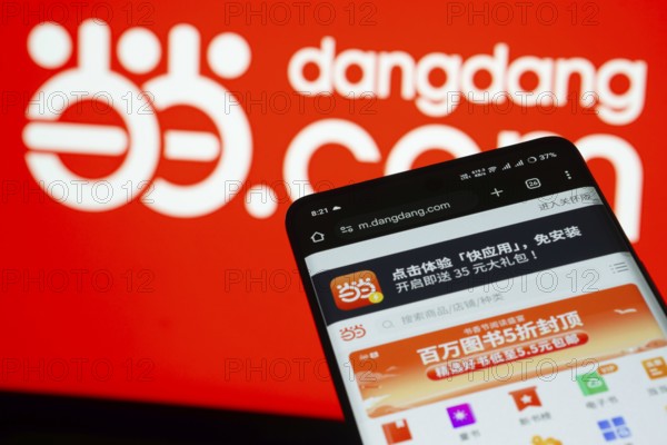Dhaka, Bangladesh- 03 Oct 2025: Smartphone displaying Dangdang.com web interface against Dangdang.com logo background
