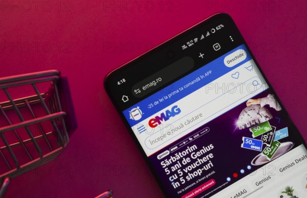 Dhaka, Bangladesh- 03 Oct 2025: A smartphone displaying the Emag website with a shopping cart is shown on a vibrant background