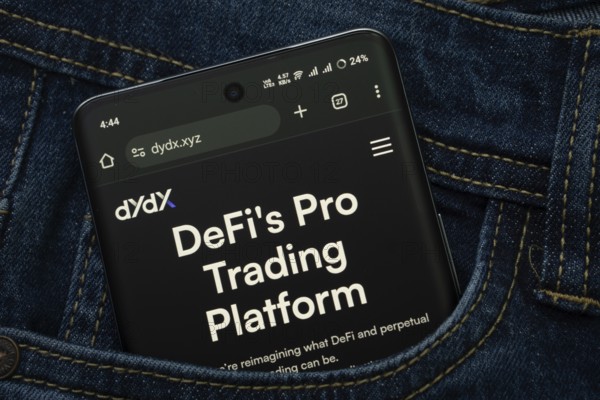 Dhaka, Bangladesh- 03 Oct 2025: A smartphone displaying the Dydx web interface peeks out of a denim pocket