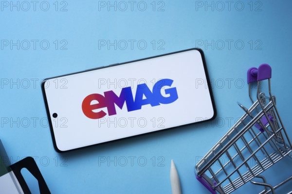 Dhaka, Bangladesh- 03 Oct 2025: Smartphone displaying Emag logo with shopping cart on a blue background