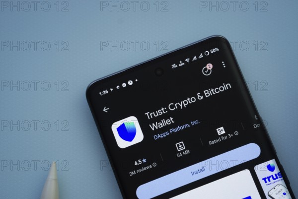 Dhaka, Bangladesh- 30 Sep 2025: On a blue surface, a smartphone displays the Trust Wallet app within the Google Play Store