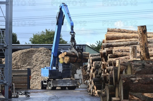 Wood storage and mechanical log transport on the premises of Energie-Mann in the Westerwald. Wood pellets are produced there