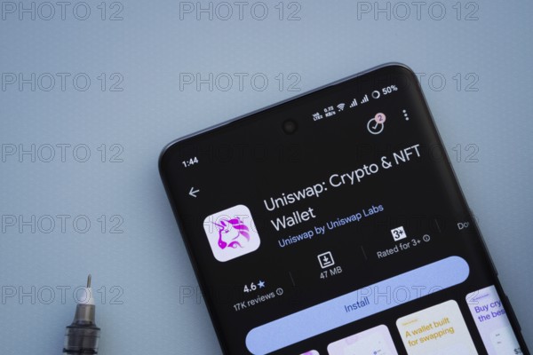 Dhaka, Bangladesh- 29 May 2025: On a blue surface, a smartphone displays the Uniswap app within the Google Play Store