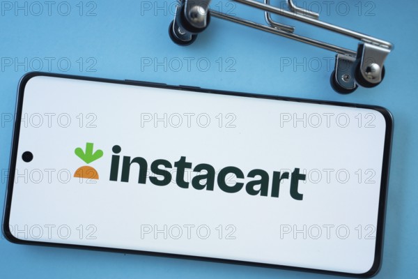 Dhaka, Bangladesh- 03 July 2025: Smartphone screen showing the Instacart logo with shopping cart wheels on a blue background