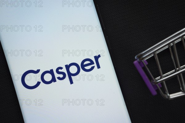 Dhaka, Bangladesh- 03 July 2025: A smartphone displaying the Casper logo next to a miniature shopping cart on a background
