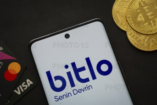 Dhaka, Bangladesh- 03 Sep 2025: Smartphone displaying Bitlo logo surrounded by Bitcoin coins and payment cards