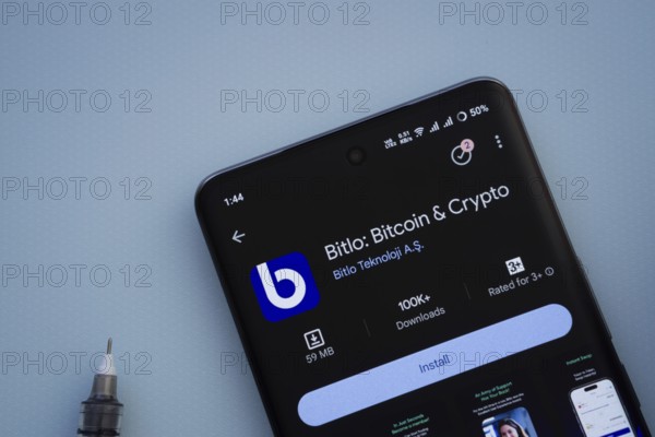 Dhaka, Bangladesh- 29 May 2025: On a blue surface, a smartphone displays the Bitlo app within the Google Play Store