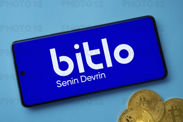 Dhaka, Bangladesh- 03 Sep 2025: Bitlo logo on smartphone screen near Bitcoin coin and QR code on blue background