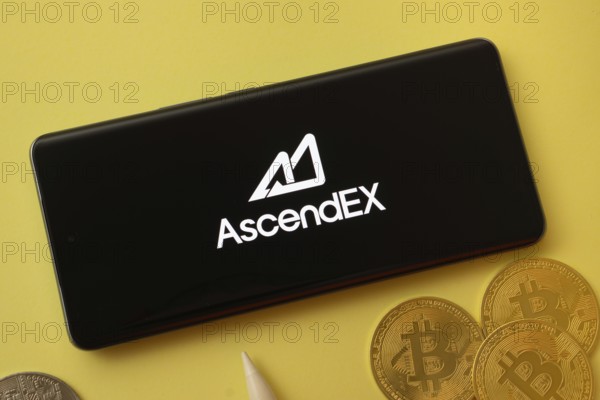 Dhaka, Bangladesh- 02 June 2025: AscendEX logo on smartphone screen near Bitcoin coin and QR code on background