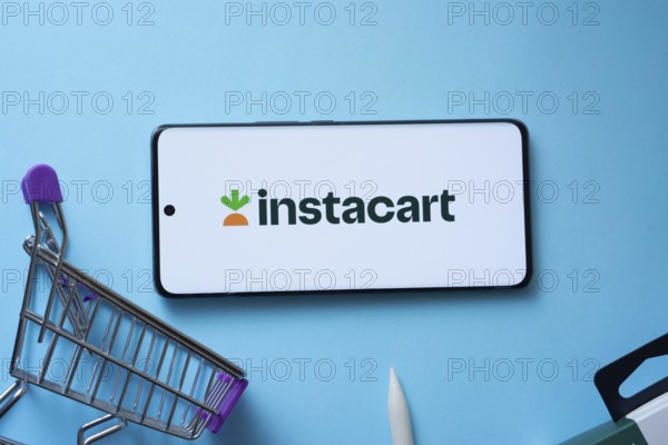 Dhaka, Bangladesh- 03 July 2025: Smartphone displaying Instacart logo with shopping cart on a blue background