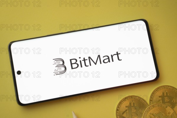 Dhaka, Bangladesh- 15 June 2025: Bitmart logo on smartphone screen near Bitcoin coin and QR code on blue background