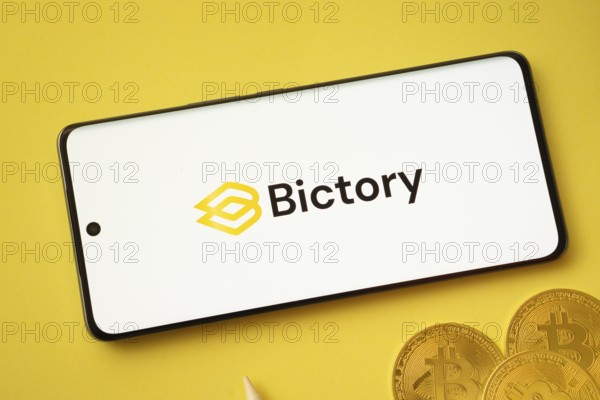 Dhaka, Bangladesh- 09 Sep 2025: Bictory logo on smartphone screen near Bitcoin coin and QR code on background