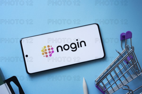 Dhaka, Bangladesh- 03 July 2025: Smartphone displaying nogin logo with shopping cart on a blue background