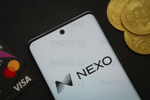 Dhaka, Bangladesh- 06 Sep 2025: Smartphone displaying nexo logo surrounded by Bitcoin coins and payment cards