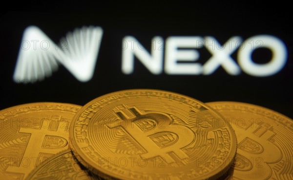 Dhaka, Bangladesh- 06 Sep 2025: Close-up of Bitcoin coins with the Nexo logo visible on a screen in the background