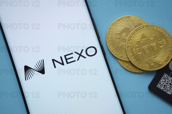 Dhaka, Bangladesh- 06 Sep 2025: Nexo logo on smartphone screen near Bitcoin coin and QR code on blue background