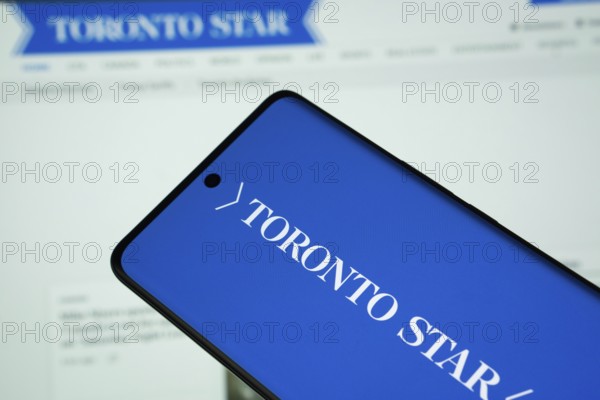 Dhaka, Bangladesh - 18 March 2025: The logo of the toronto star is displayed on a smartphone screen, and the website is visible on a computer screen in the background