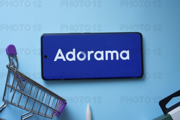 Dhaka, Bangladesh- 03 July 2025: Smartphone displaying Adorama logo with shopping cart on a blue background