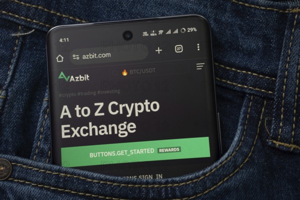 Dhaka, Bangladesh- 15 June 2025: A smartphone displaying the Azbit.com web interface peeks out of a denim pocket
