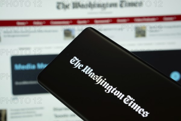 Dhaka, Bangladesh - 18 March 2025: The logo of the washinton times is displayed on a smartphone screen, and the website is visible on a computer screen in the background