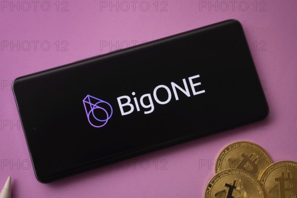 Dhaka, Bangladesh- 15 June 2025: bigONE logo on smartphone screen near Bitcoin coin and QR code on background