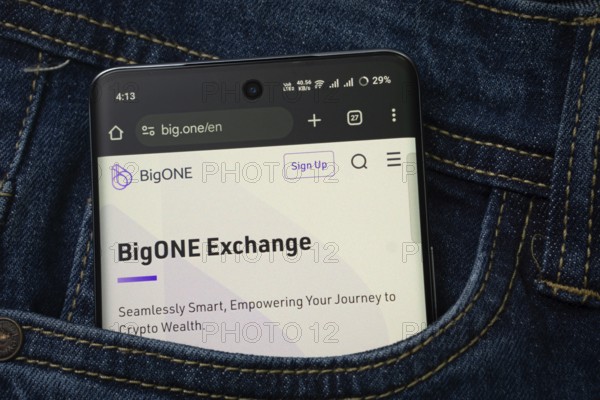 Dhaka, Bangladesh- 15 June 2025: A smartphone displaying the BigONE web interface peeks out of a denim pocket