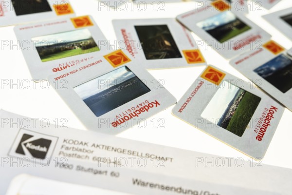 Many framed Kodachrome slides on a light table with magnifying glass, top shot