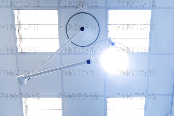 Bright operating or treatment room, view of medical examination light and ceiling lighting from the patient's point of view