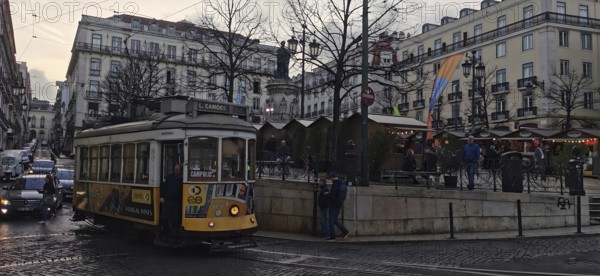 Historic tram on a busy city street surrounded by classic buildings, Lisbon, Portugal