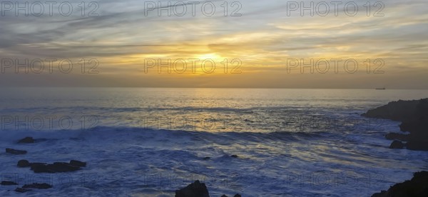 The sun sets over the ocean with visible waves, hiking the Fisherman's Trail, fishing trail, rota vicentina, Porto Covo, Alentejo region, Portugal