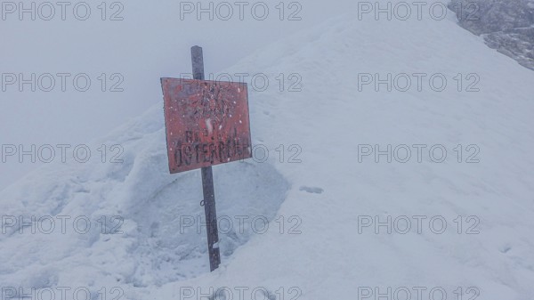 Snow-covered landscape with a sign Republic of Austria, on the way to Zugspitze during snowstorm, Zugspitze, Alps