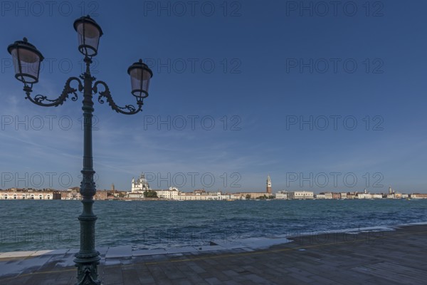 View of Venice from the island of San Giorgio Maggiore, with the church of Santa Maria della Salute and St Mark's Tower, in front the Venetian lagoon, Venice, Veneto, Italy