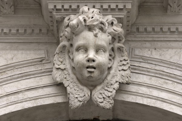 Sculpture of an angel's head above an entrance portal, Venice, Veneto, Italy
