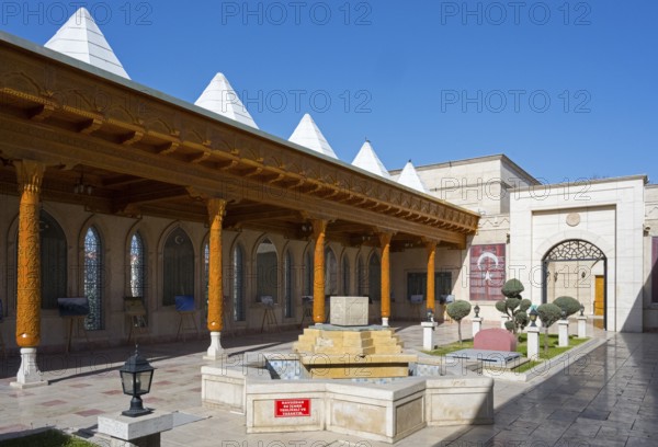 Traditional courtyard with fountain and decorated wooden pillars under clear skies, Istiklal Harbi Sehitleri Abidesi, Memorial, War Memorial to the Victims of the Revolutionary War, Konya, Central Anatolia, Turkey