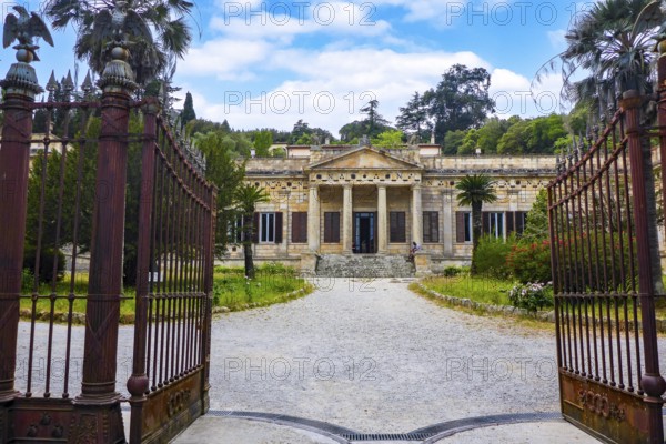 View through open old wrought-iron gate to main entrance with staircase and columned portal of historic Villa San Martino residence of Emperor Napoleon Bonaparte during exile on Elba Island, Portoferraio, Elba, Tuscany, Italy