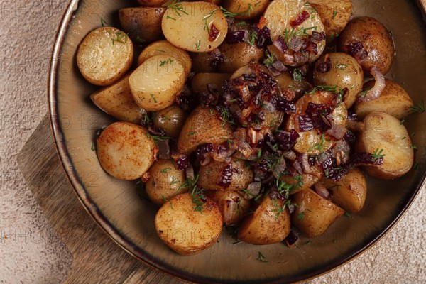 Golden roasted potatoes are enhanced with caramelized onions and fresh herbs, creating a savory dish perfect for any meal. This appealing side showcases rustic flavors