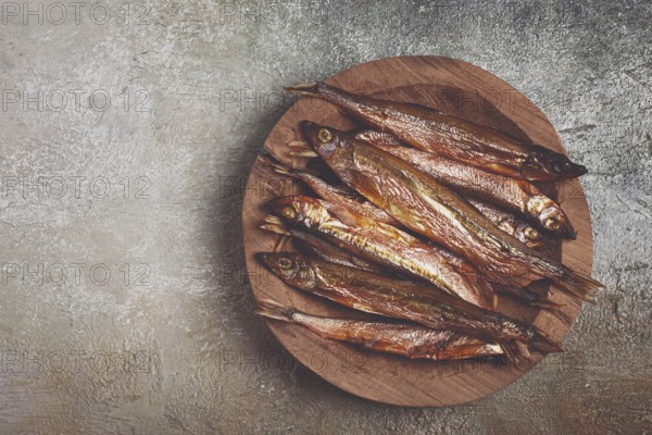 Cold smoked capelin, on a wooden bowl, top view, no people