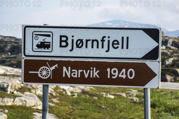 Signpost to Bjørnfjell railway station, railway line Kiruna-Narvik, and world war II memorial, battle of Narvik 1940, Norway