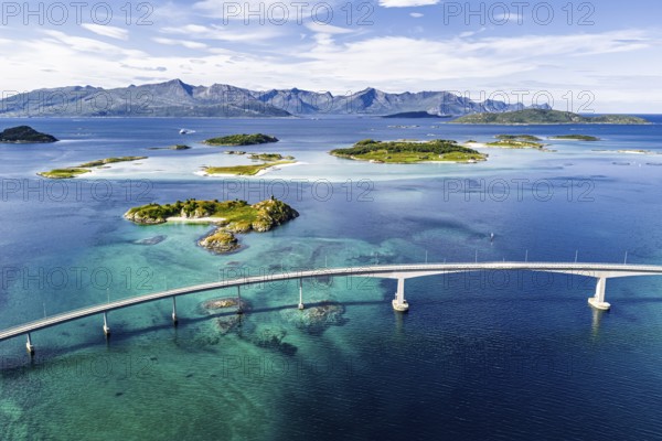 Sommaroy Bridge connecting Kvaloya Island to Sommaroy Island, small islands, mountain range in the back, turquoise water, aerial view, Norway