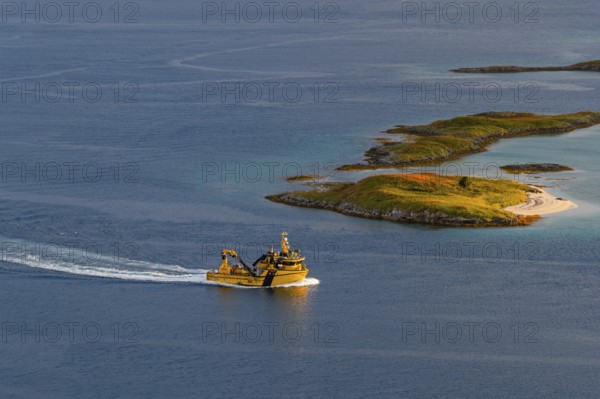 Boat passing islands near Sommaroy Bridge, warm light at sunset, aerial view, Norway