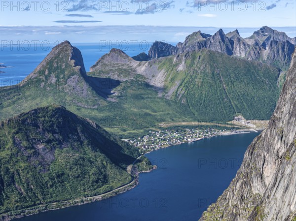 Aerial view from top of Mt. Grytetippen towards village Fjordgard, Mt. Segla and Mt. Hesten, Senja Island, Norway