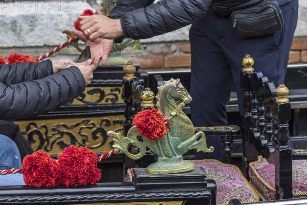 Tourist pays by mobile phone in a gondolier, Venice, Veneto, Italy