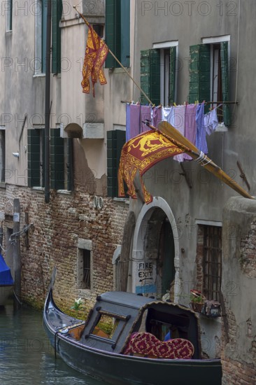 Flying flags of the Republic of Venice on a residential building, a gondola on the canal, Venice, Venice, Italy