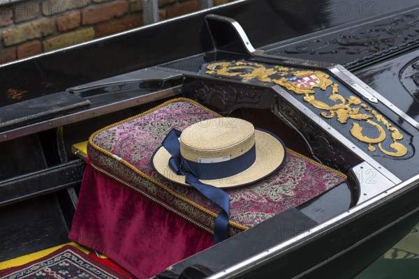 Typical straw hat of a gondolier sitting on a gondola, Venice, Veneto, Italy